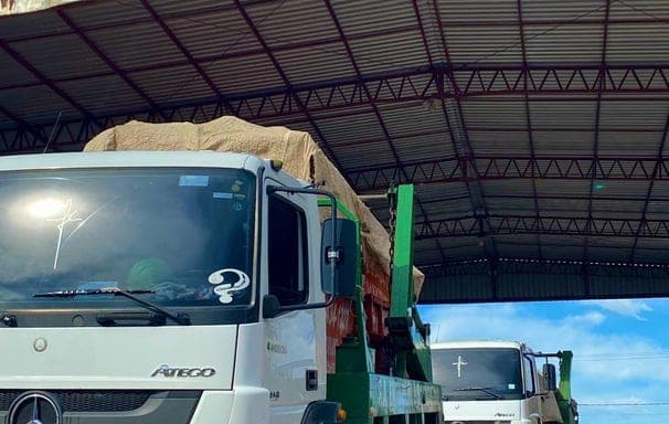 Caminhão poliguindaste do Entulho Manaus carregado, sob o galpão do pátio